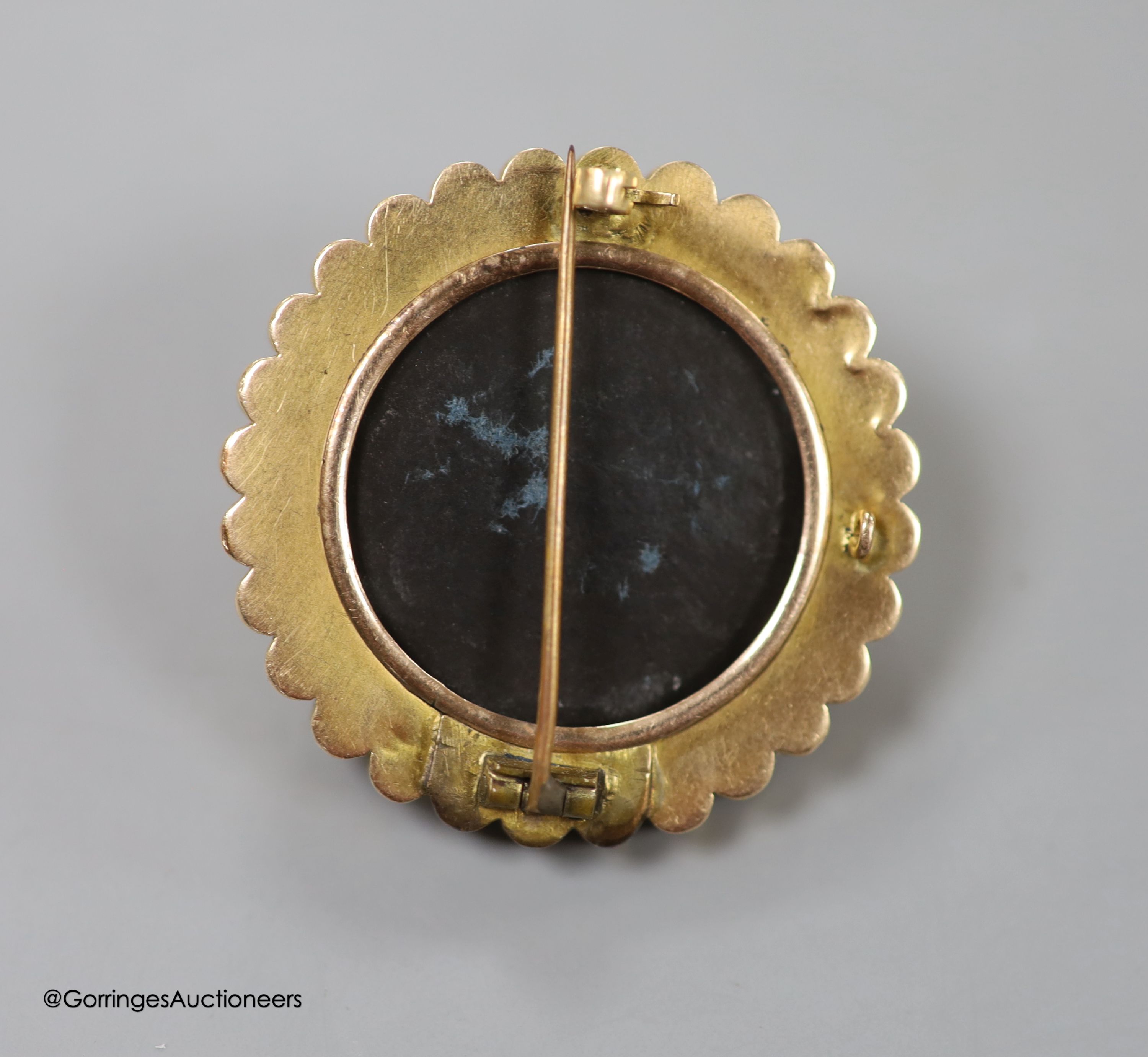 A Victorian yellow metal circular brooch, with central foliate motif, 38mm, gross 13.5 grams.